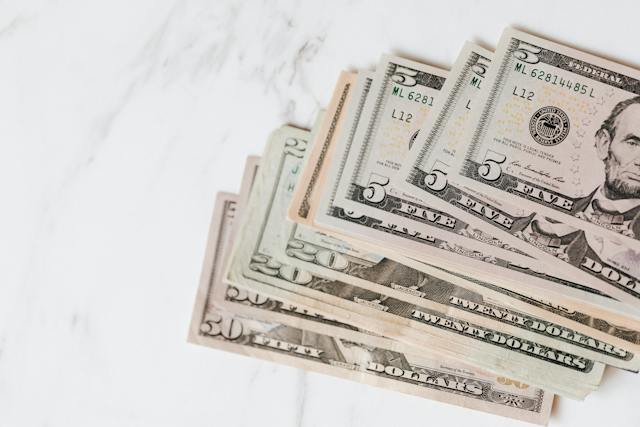 Various dollar bills on a surface.