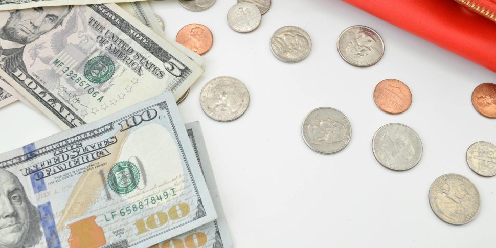 Coins and cash on a plain white surface.